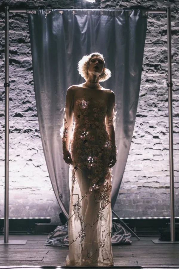 A model wearing a floor-length light-emitting garment with LEDs tracing the fabric
