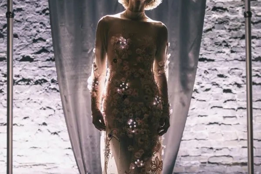 A model wearing a floor-length light-emitting garment with LEDs tracing the fabric