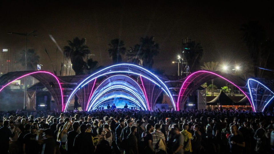 Blue and violet illuminated arches spanning the Primavera Sound festival stage above a crowd