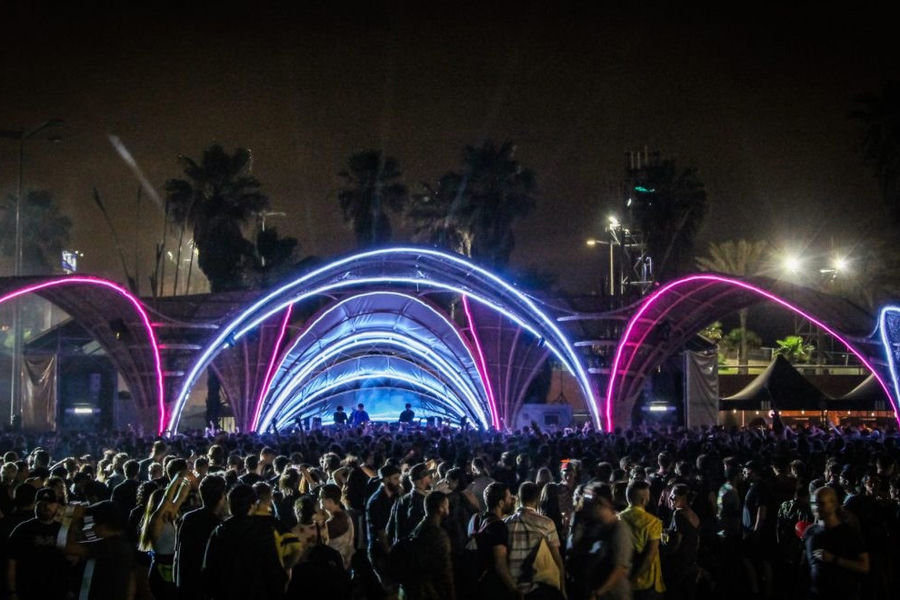 Blue and violet illuminated arches spanning the Primavera Sound festival stage above a crowd